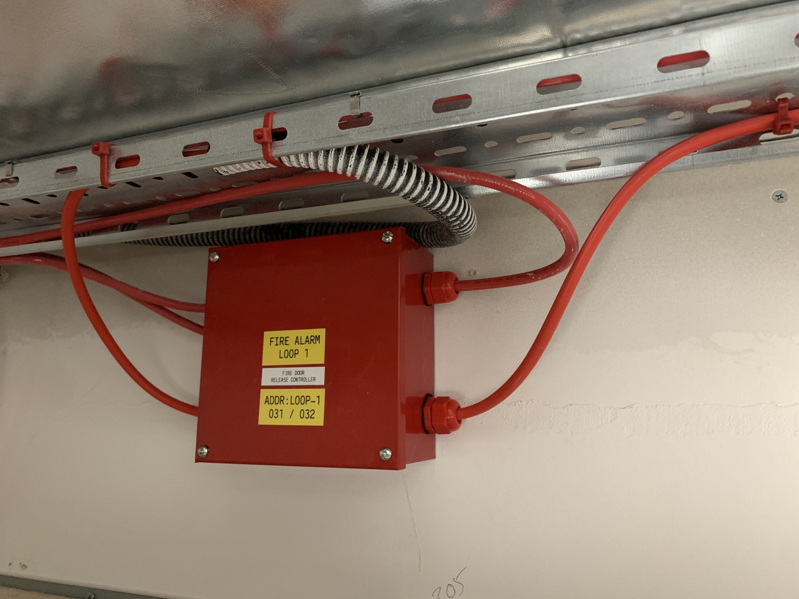 Fire door release controller interfaced with the fire alarm loop