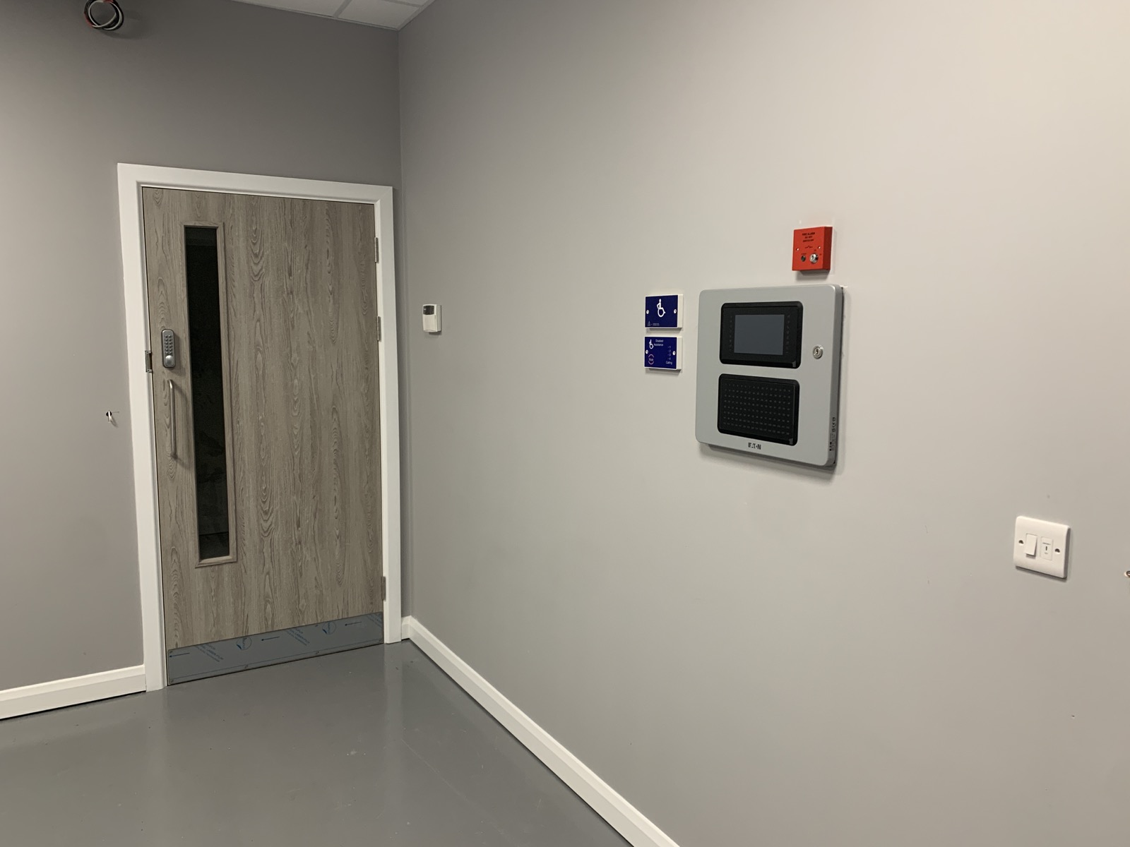 Eaton xDetect panel and alarm call point in a finished commercial interior